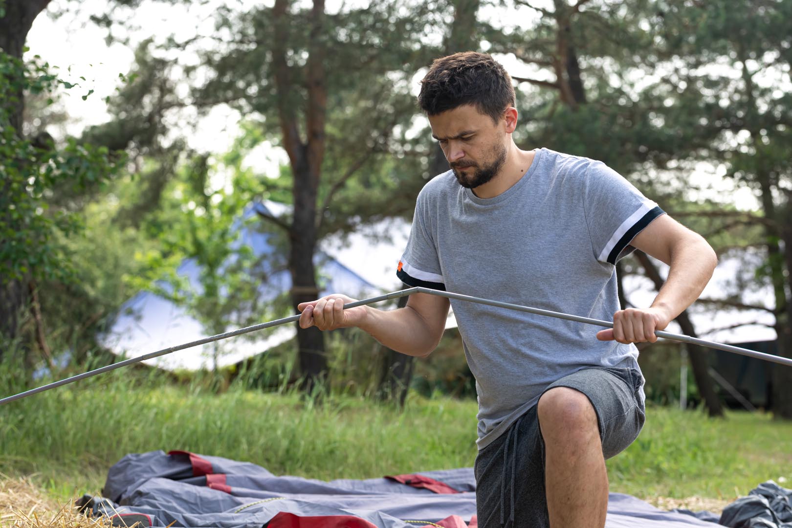 Camping travel tourism hike concept young man setting up tent outdoors