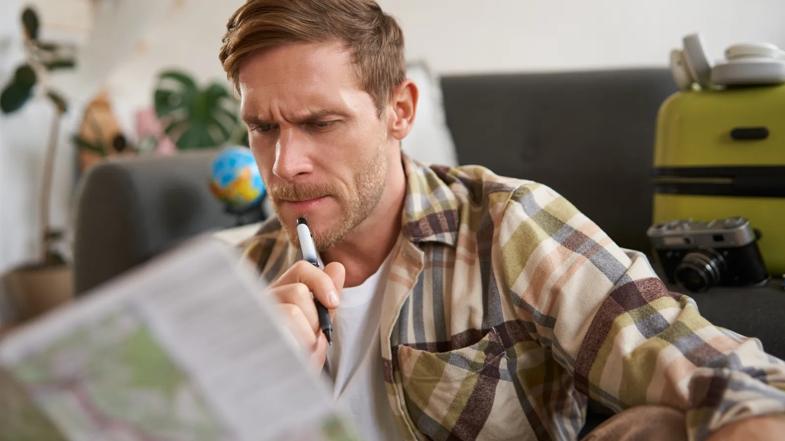 Camper studying a paper map at home while packing for a summer trip