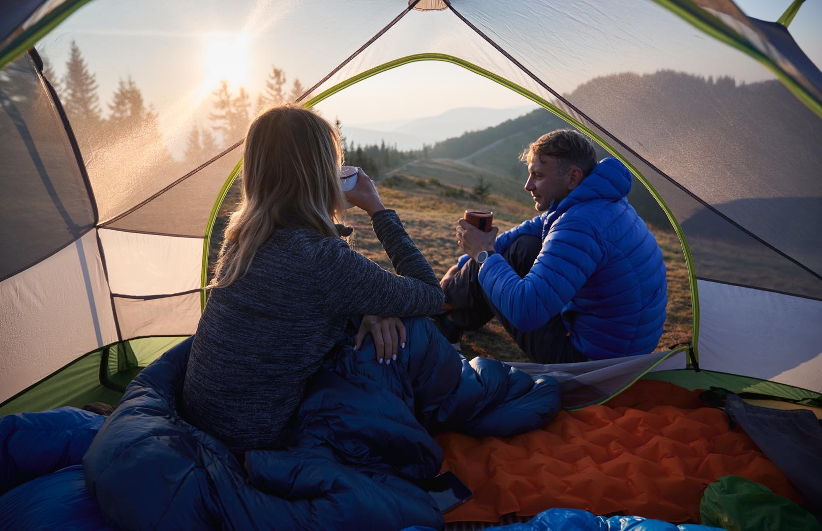Young couple travelers drinking coffee camping trip mountains